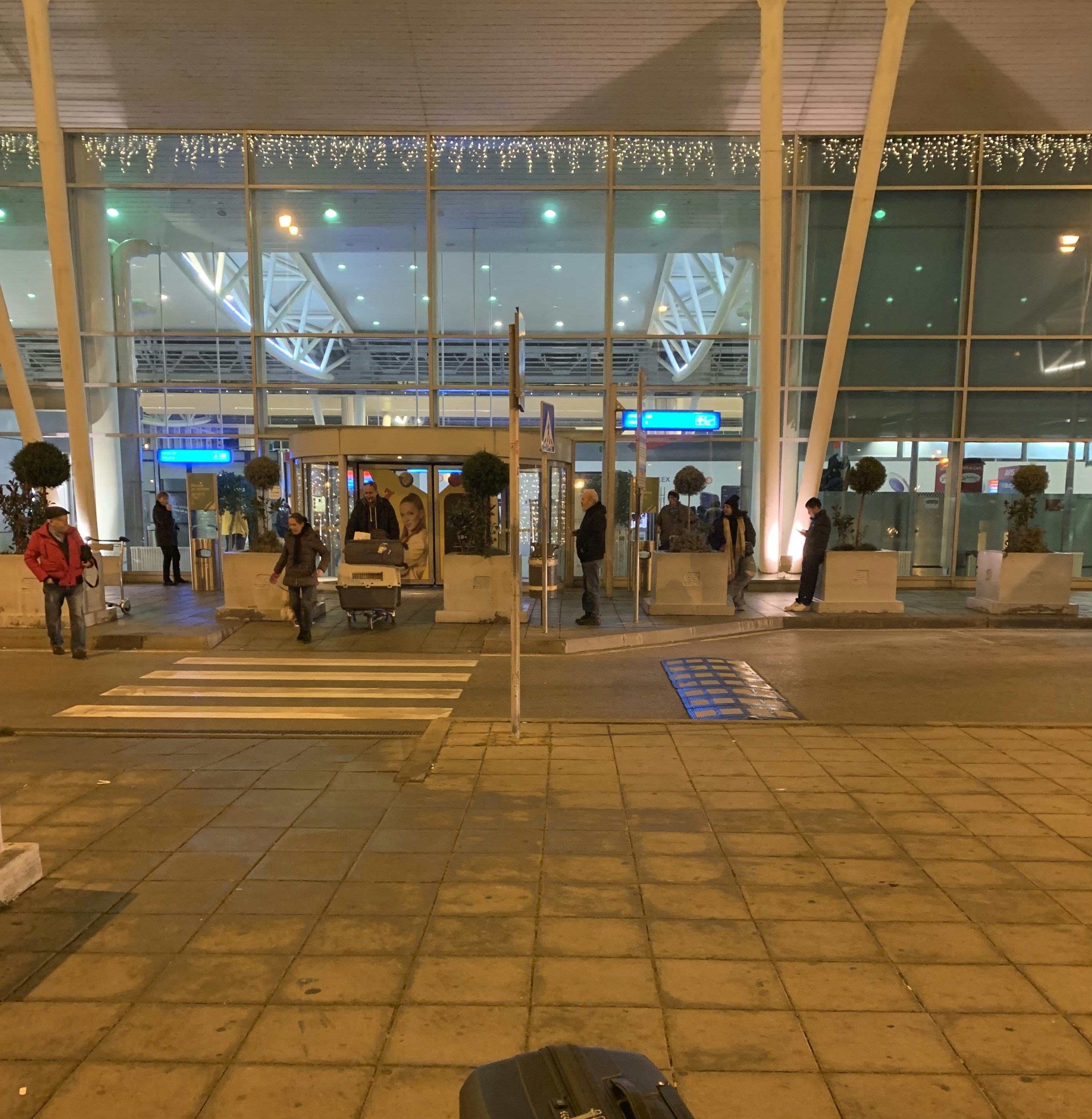 Happy international travelers with luggage arriving at hotel entrance in Africa, warm evening light