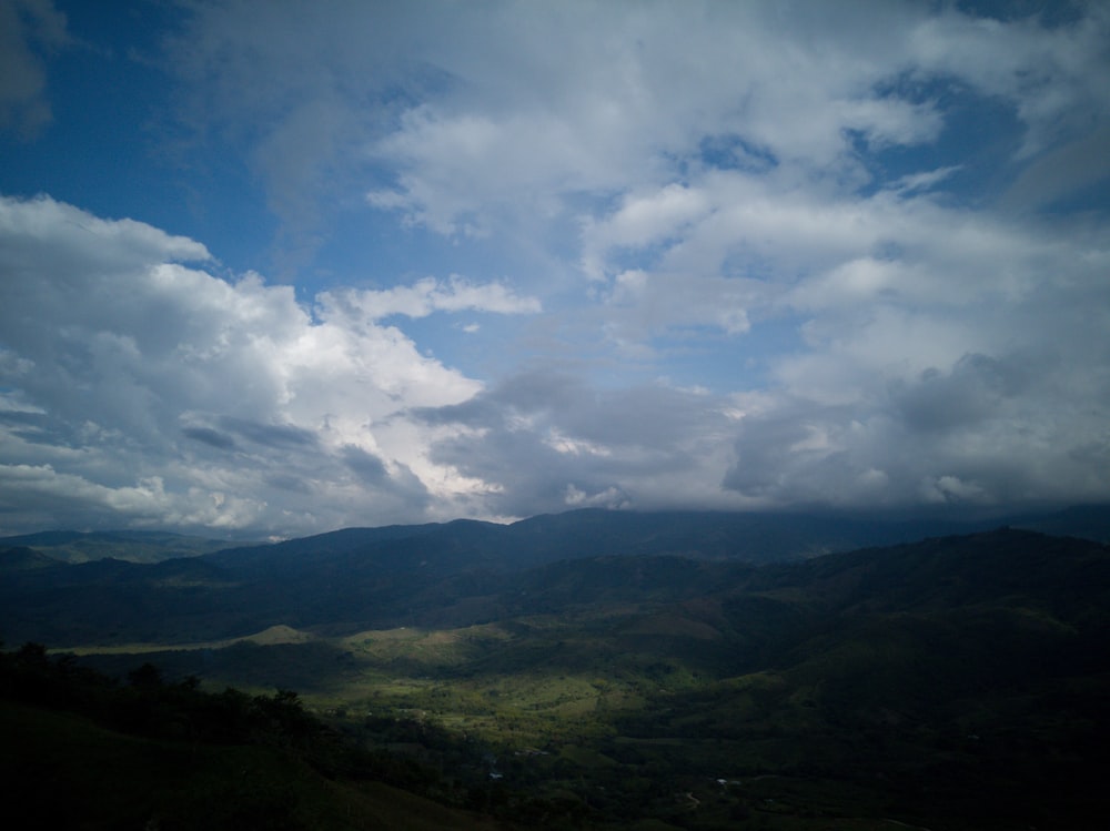 a view of a mountain range under a cloudy sky