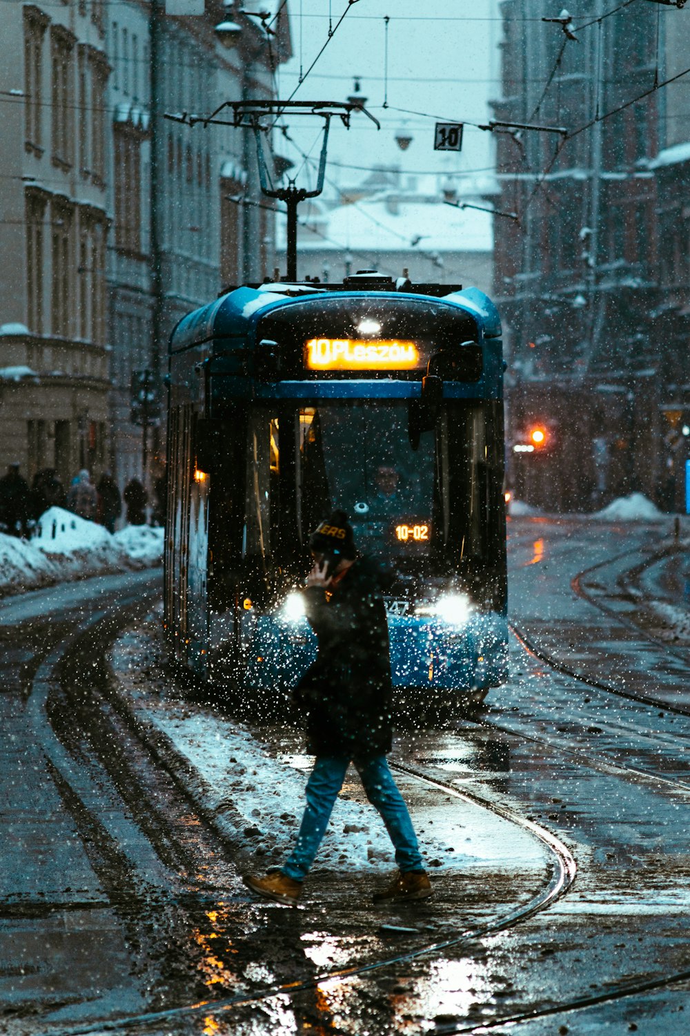 a person crossing a street in the snow