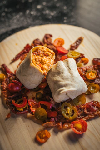 A steaming mac and cheese burrito sliced open to show gooey, melty cheese.