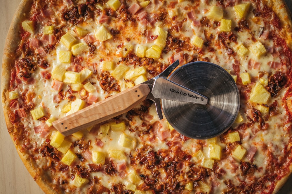 a pizza with a pizza cutter on top of it
