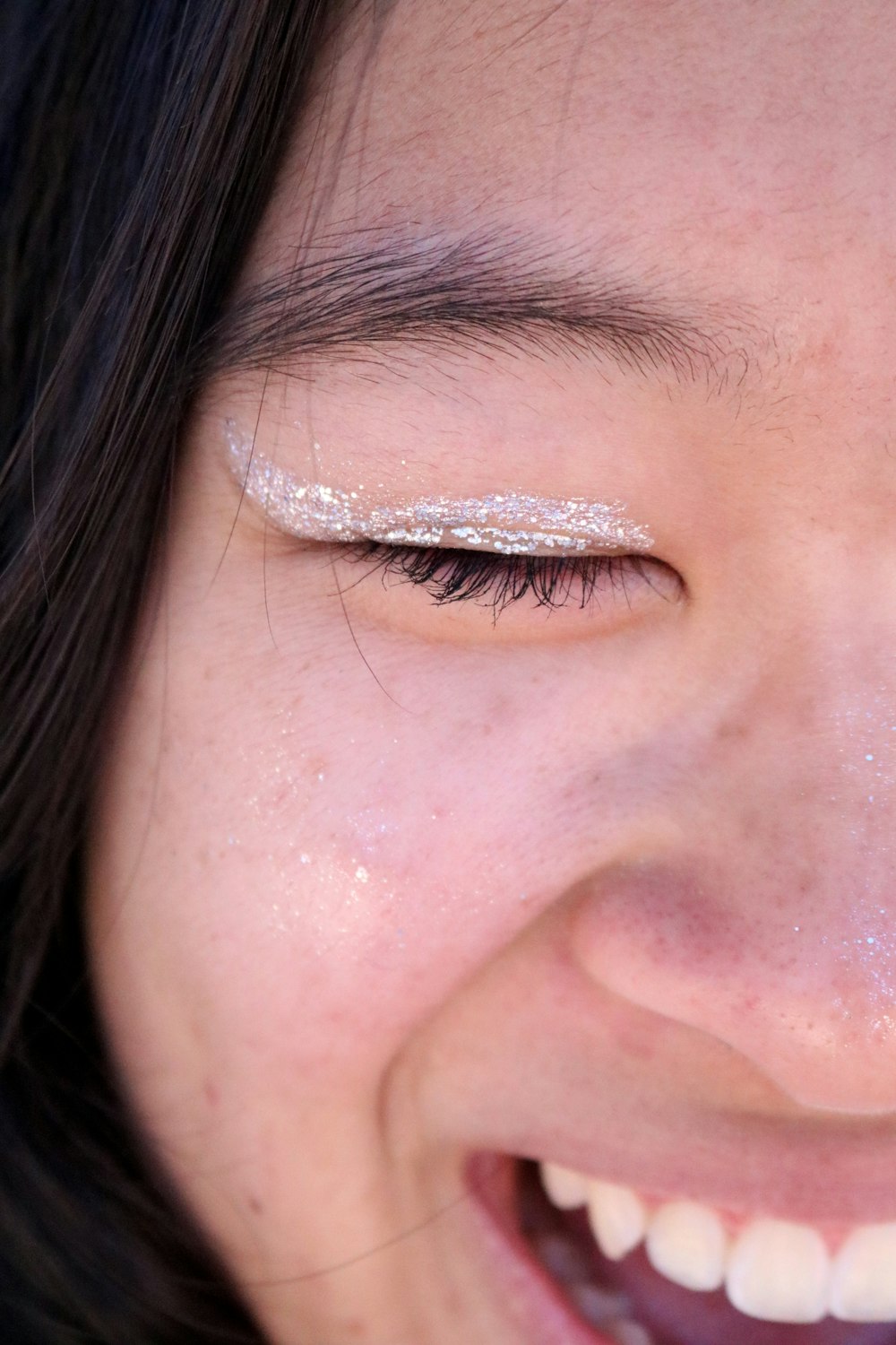 a close up of a woman's face with glitter on her eyes