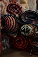 a pile of colorful rugs sitting on top of a table