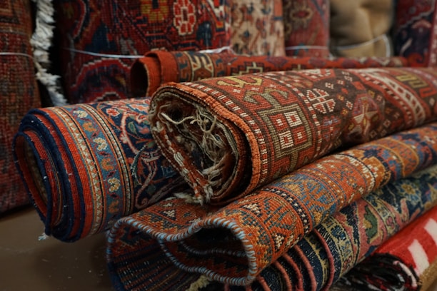 Close-up of colorful prayer mats neatly stacked in a wholesale store.