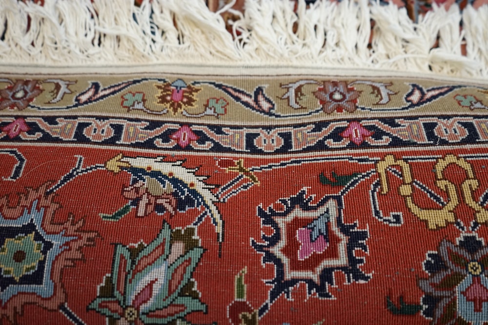 a close up of an oriental rug with tassels