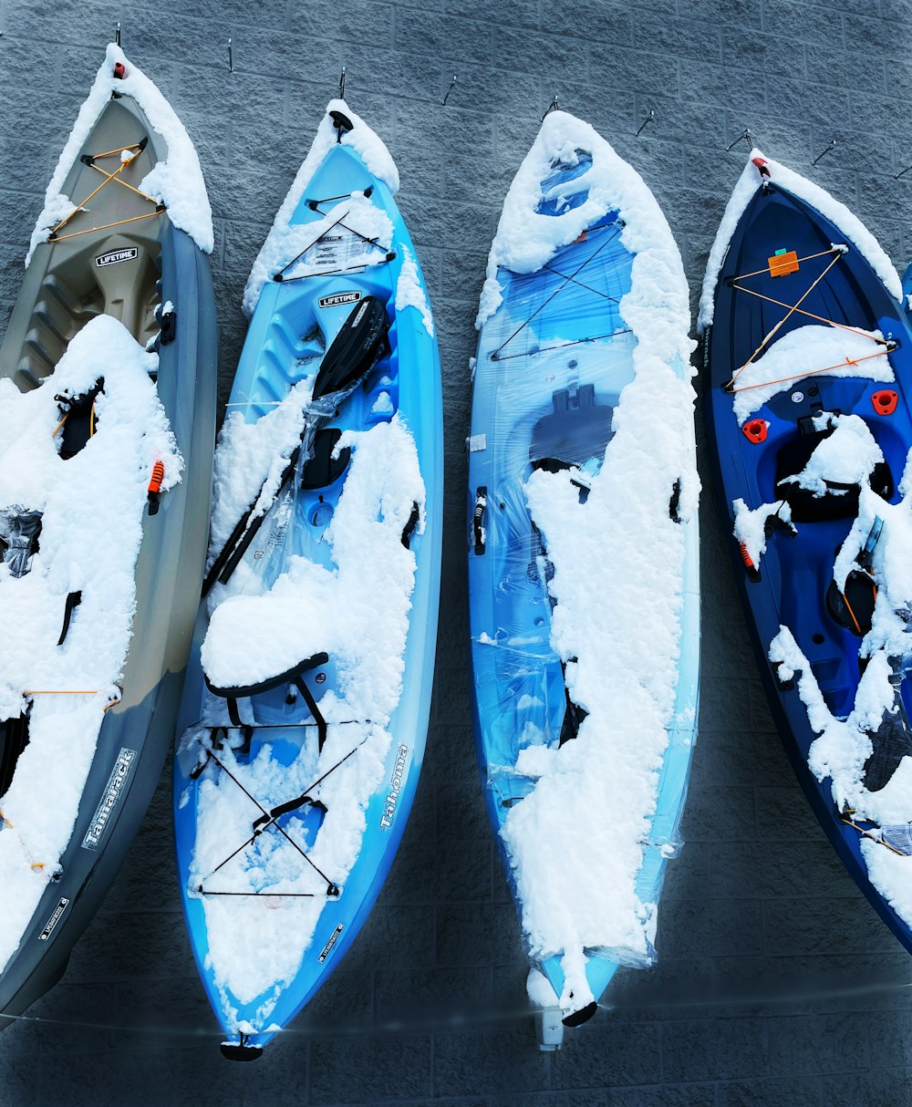 three kayaks covered in snow sitting next to each other