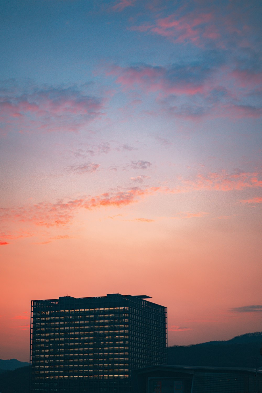 a plane flying in the sky over a building