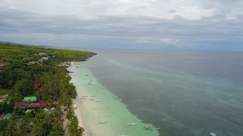 an aerial view of a beach with boats in the water