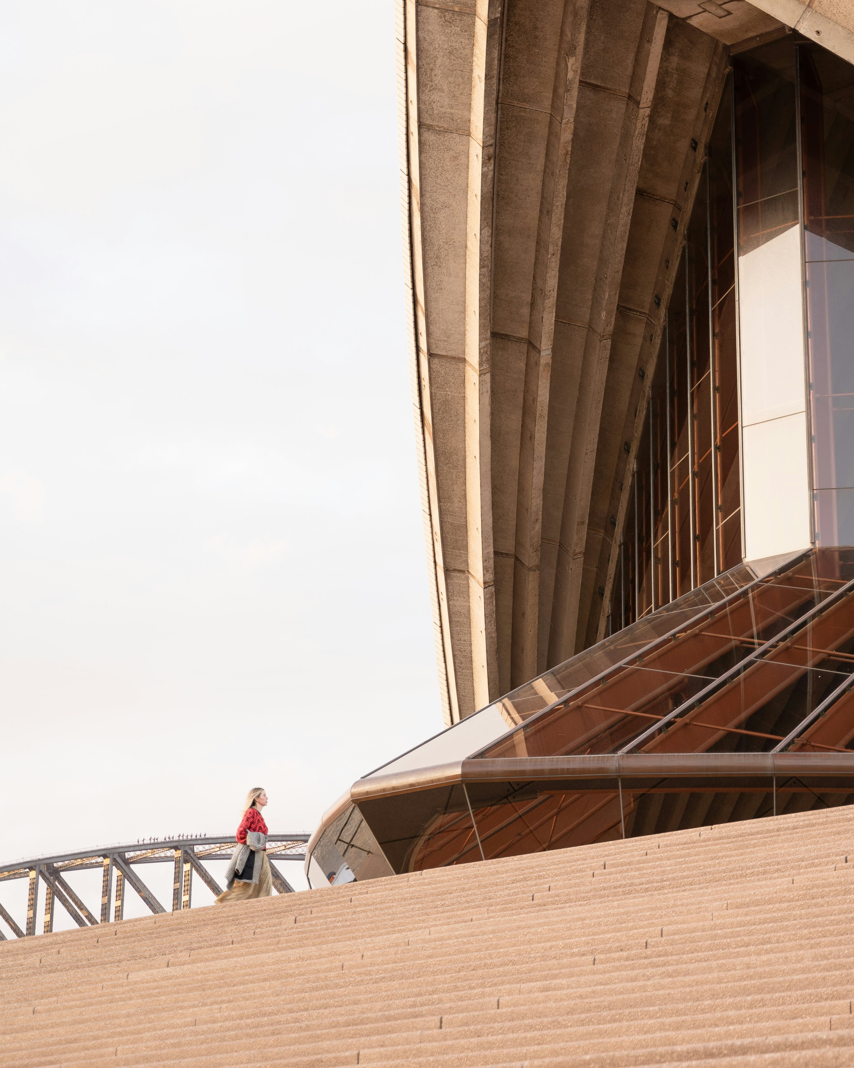 高層ビルの隣の橋を渡って歩く男