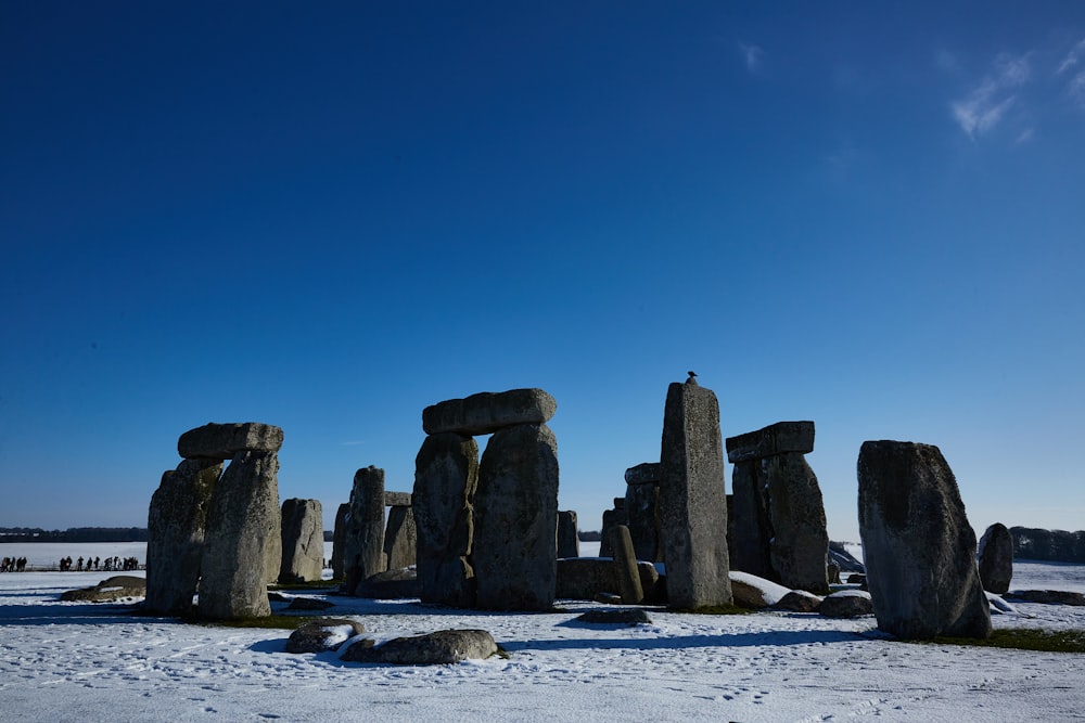 a group of stonehenge standing in the snow