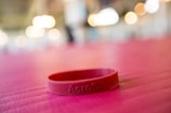 a pink bracelet sitting on top of a pink table
