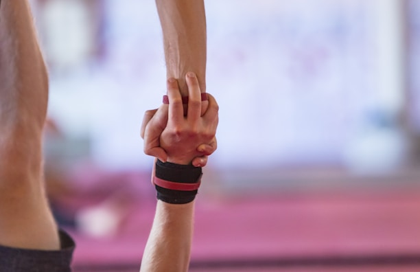 Close-up of hands gently supporting a client during a personalized Pilates exercise.