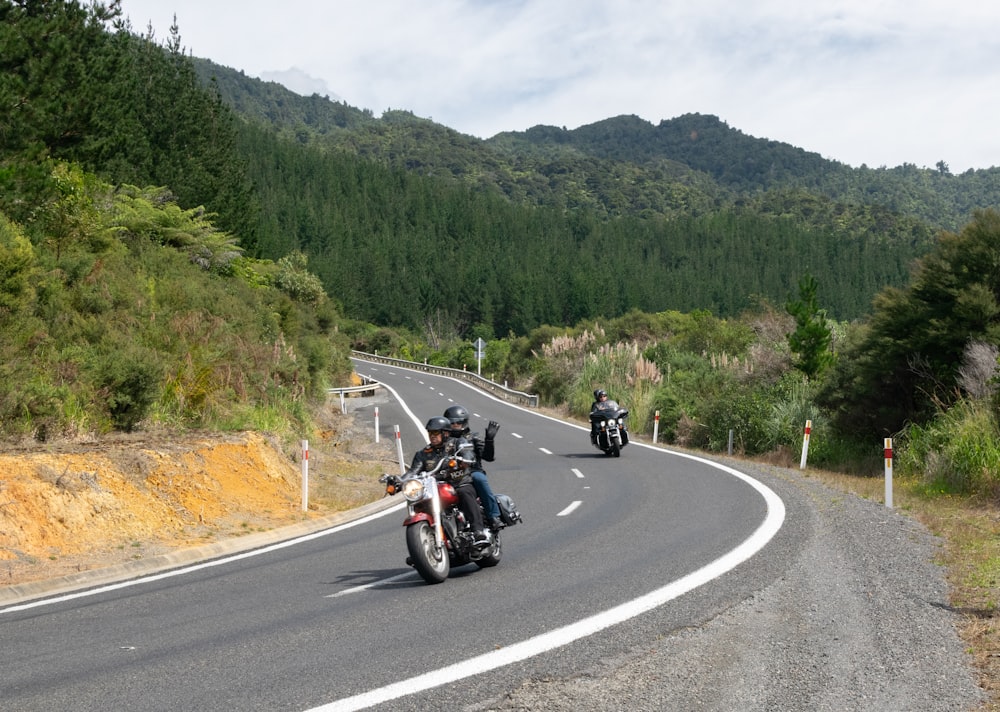 a group of people riding motorcycles down a curvy road