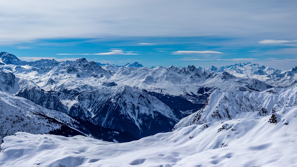 a mountain range covered in snow under a blue sky