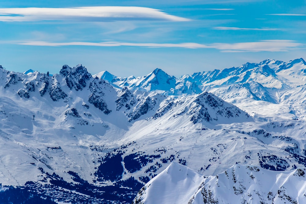 a mountain range covered in snow under a blue sky