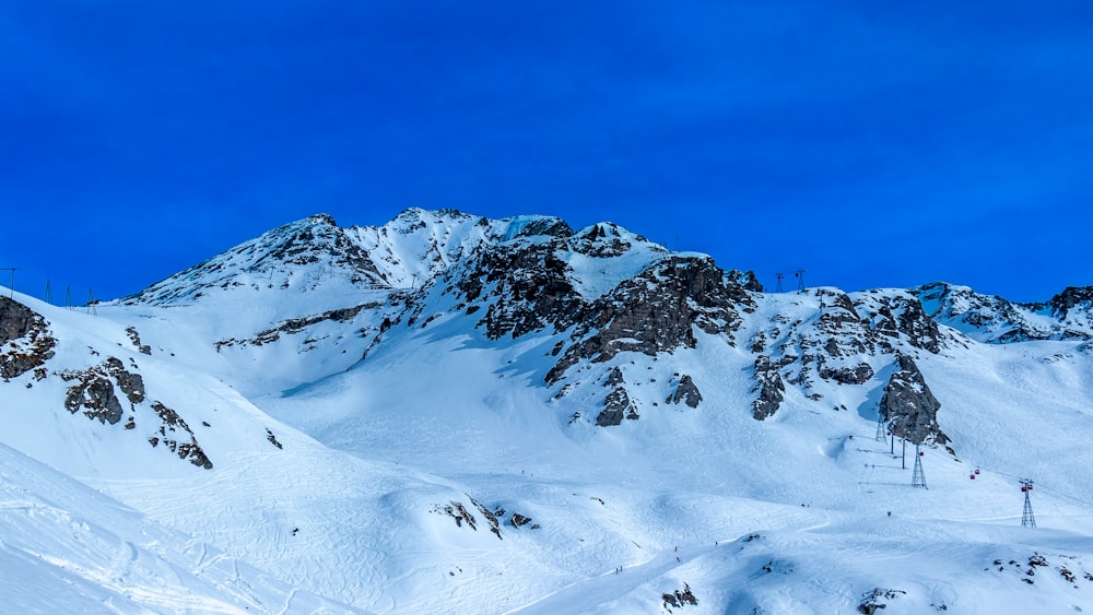 遠くにスキーリフトのある雪に覆われた山