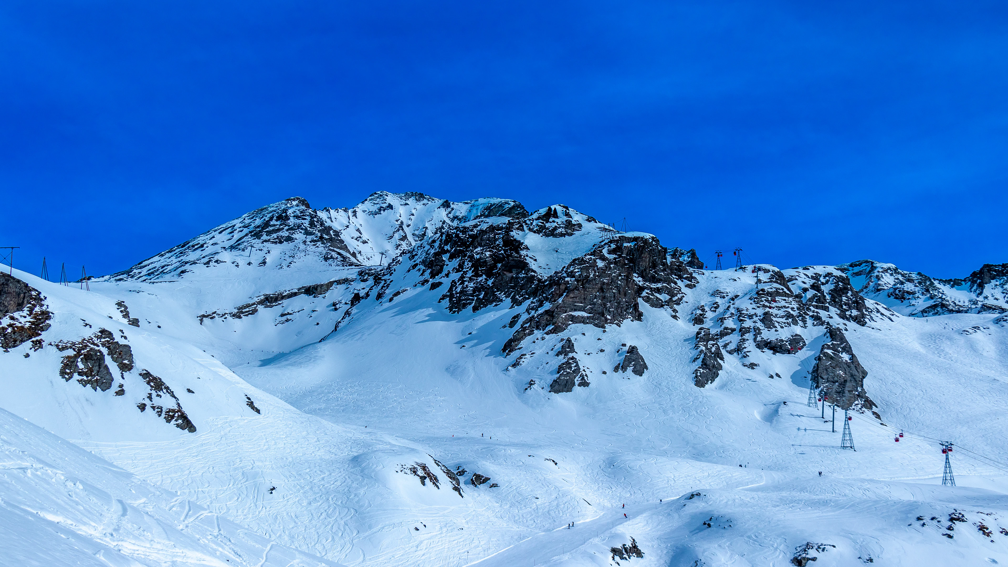 Snow-covered mountains and a ski lift above the resort, on La Plagne ski holidays
