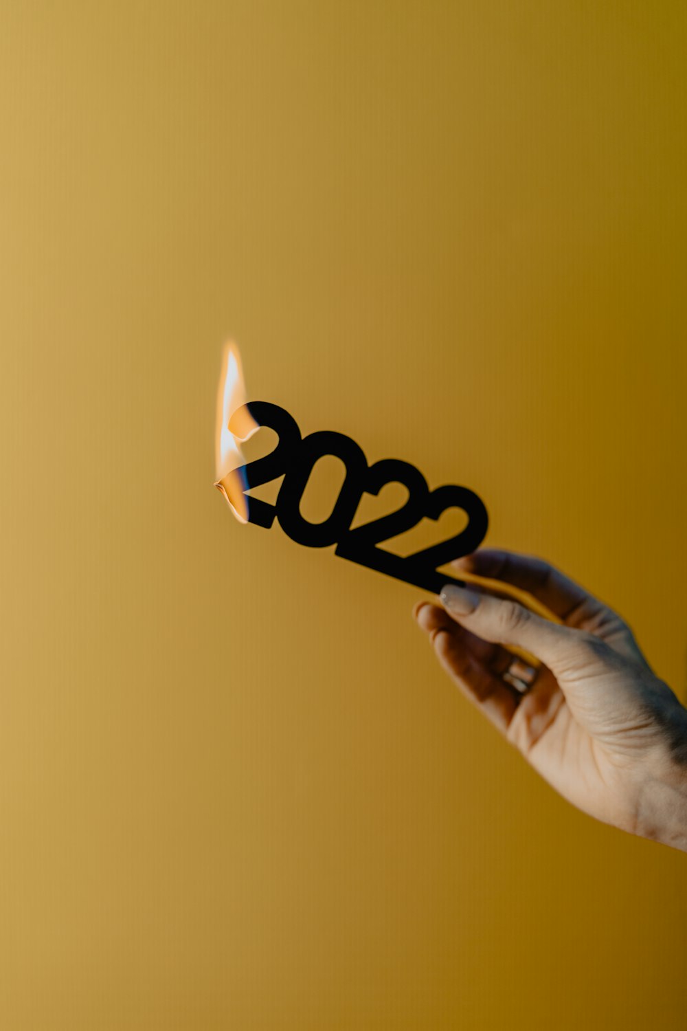 Una mano sosteniendo una cerilla encendida con los números 2012 en ella
