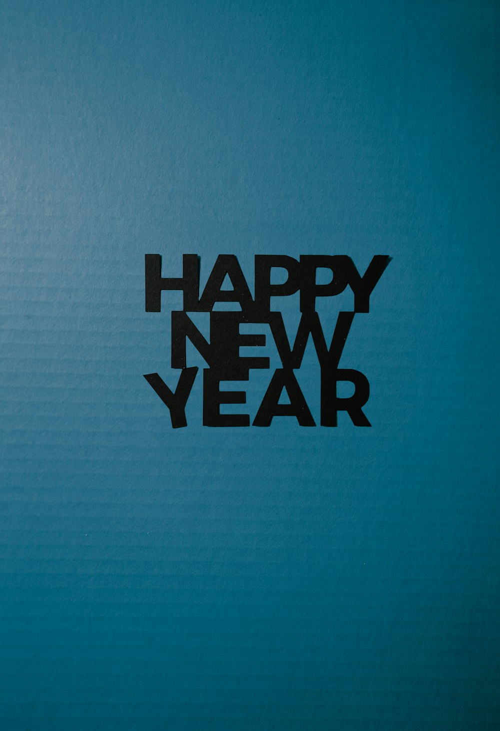 a picture of a happy new year written in black on a blue background