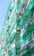 A residential building with multiple floors featuring green-tinted glass balconies and awnings. Clothes and laundry are hung out to dry on lines extending from the balconies. Air conditioning units are also visible on the walls.