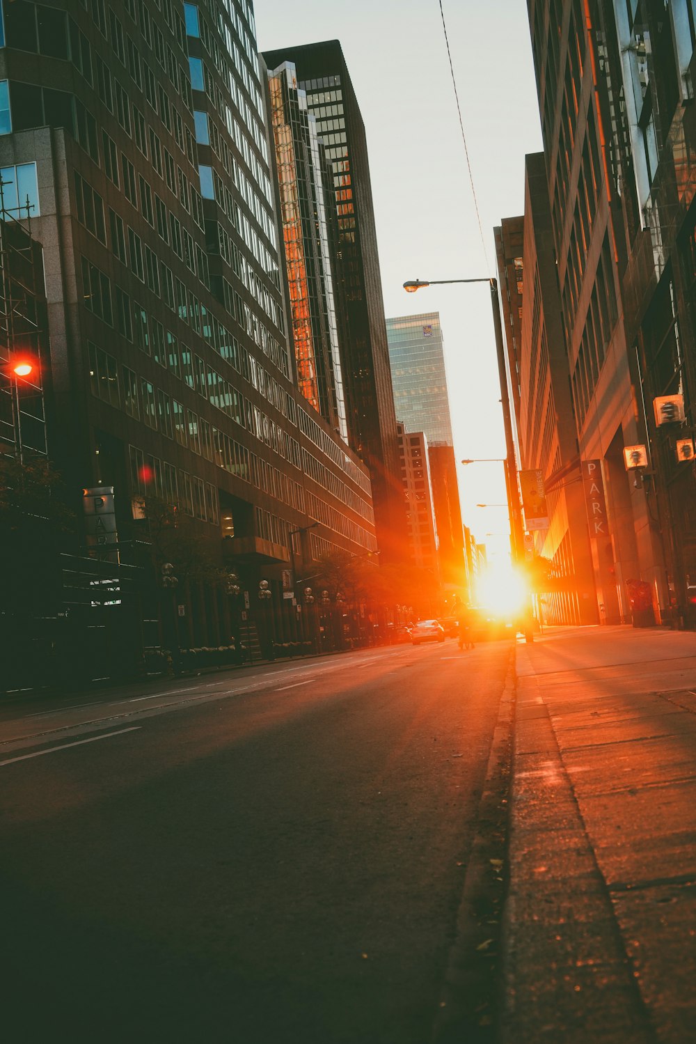 the sun is setting on a city street