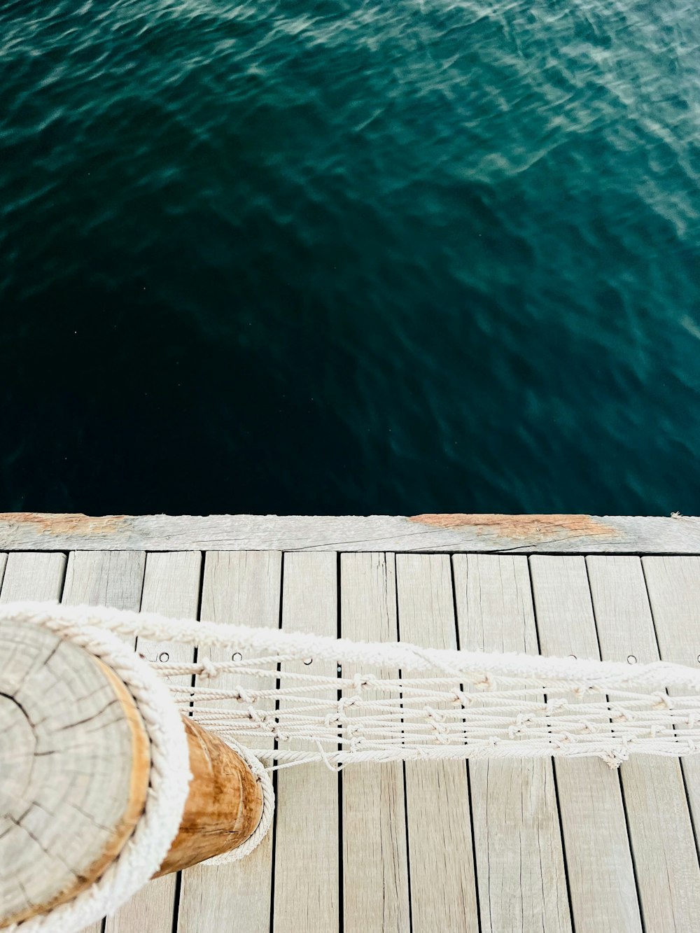 a person standing on a dock next to a body of water