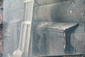 Wide shot of a rustic Norwegian log house with visible weather damage on the exterior logs.