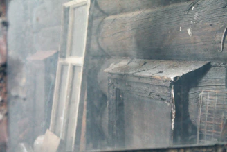 Wide shot of a rustic Norwegian log house with visible weather damage on the exterior logs.