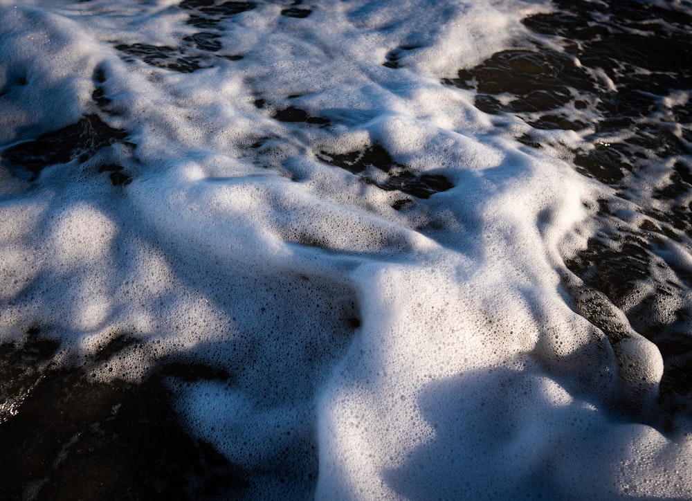 a beach covered in snow next to the ocean