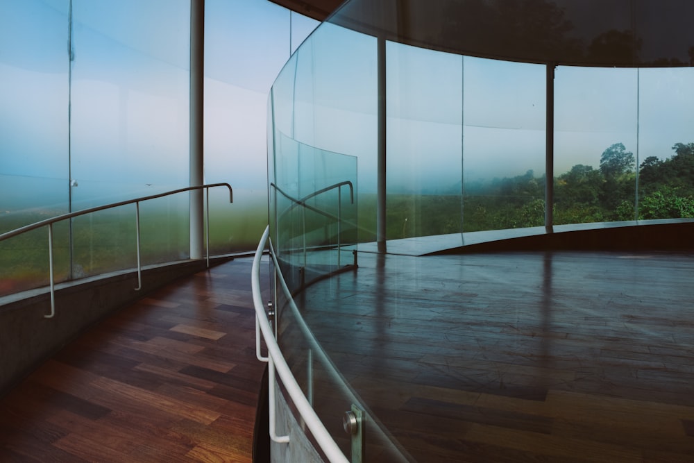 a curved room with glass walls and a wooden floor