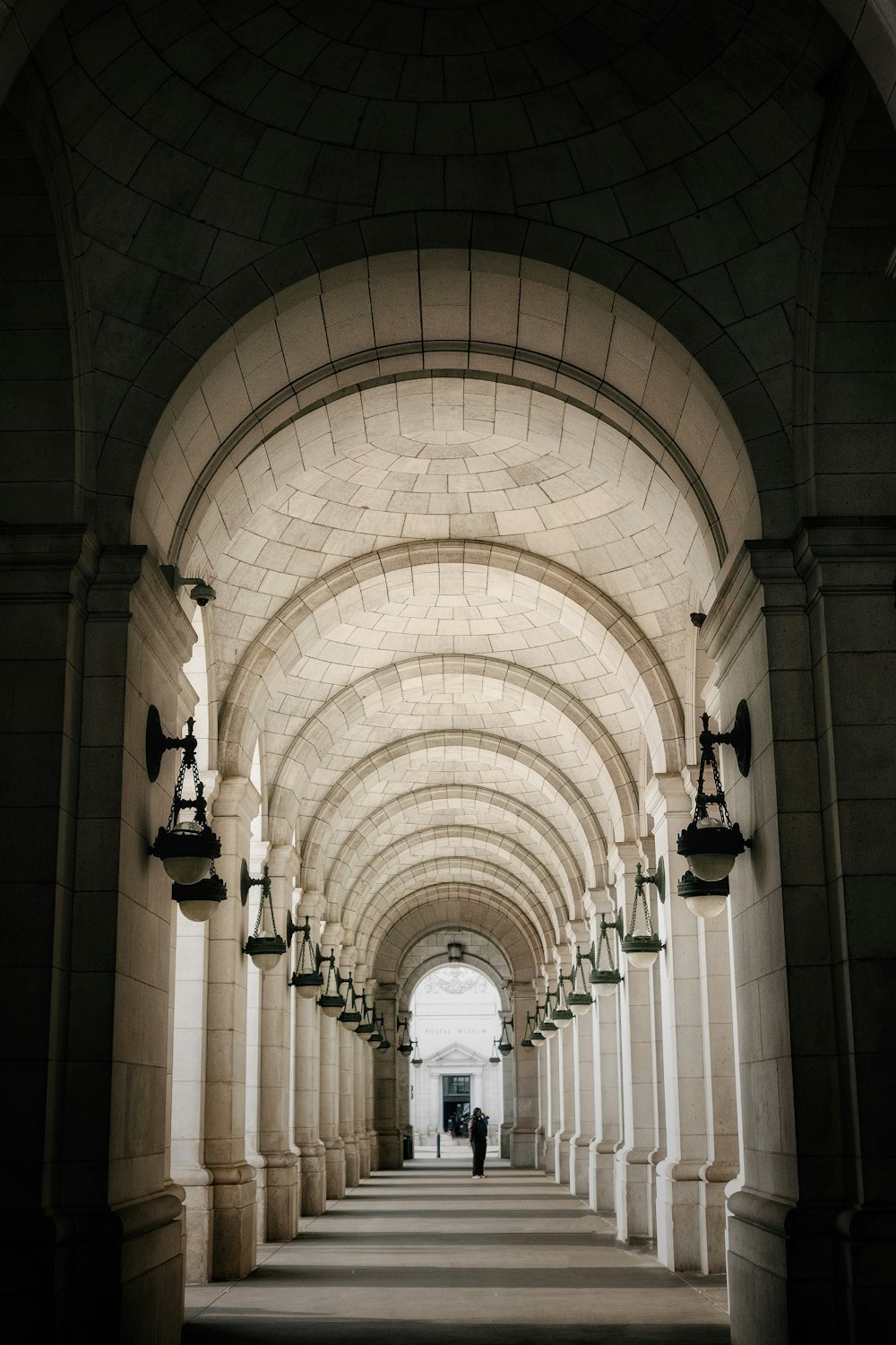 a long hallway with several lamps on either side of it