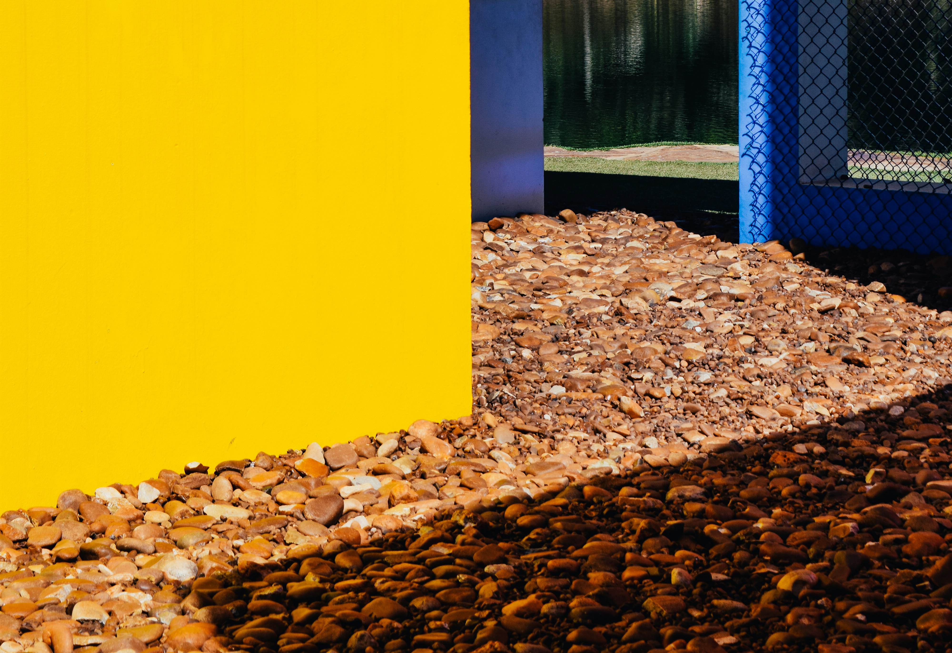 a yellow and blue building next to a pile of rocks