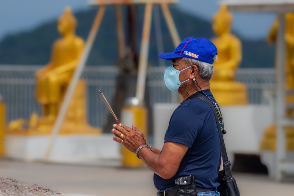 a man wearing a face mask and holding a stick