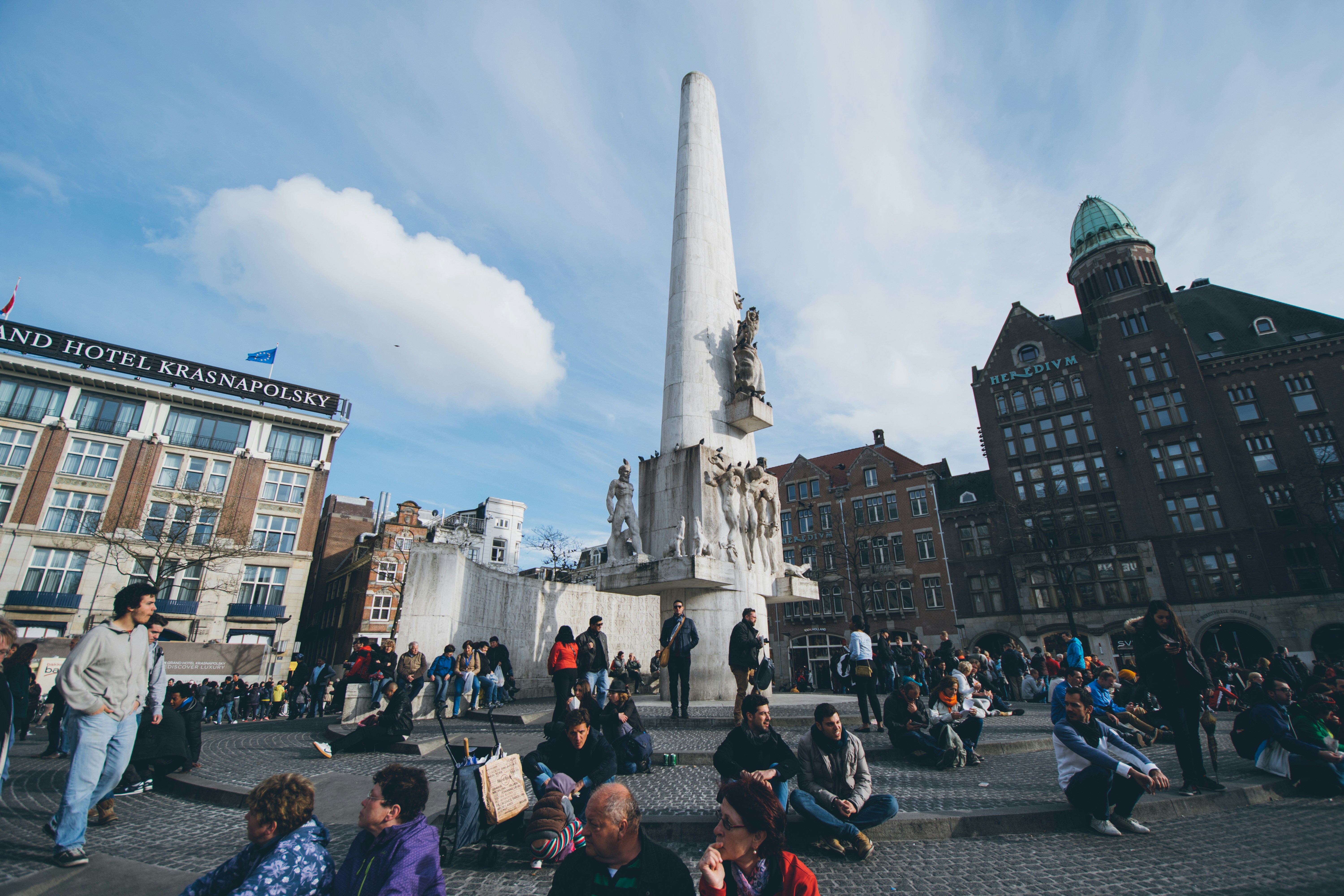 a group of people sitting on the ground in front of a monument