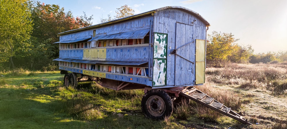 a blue and yellow building sitting in the middle of a field