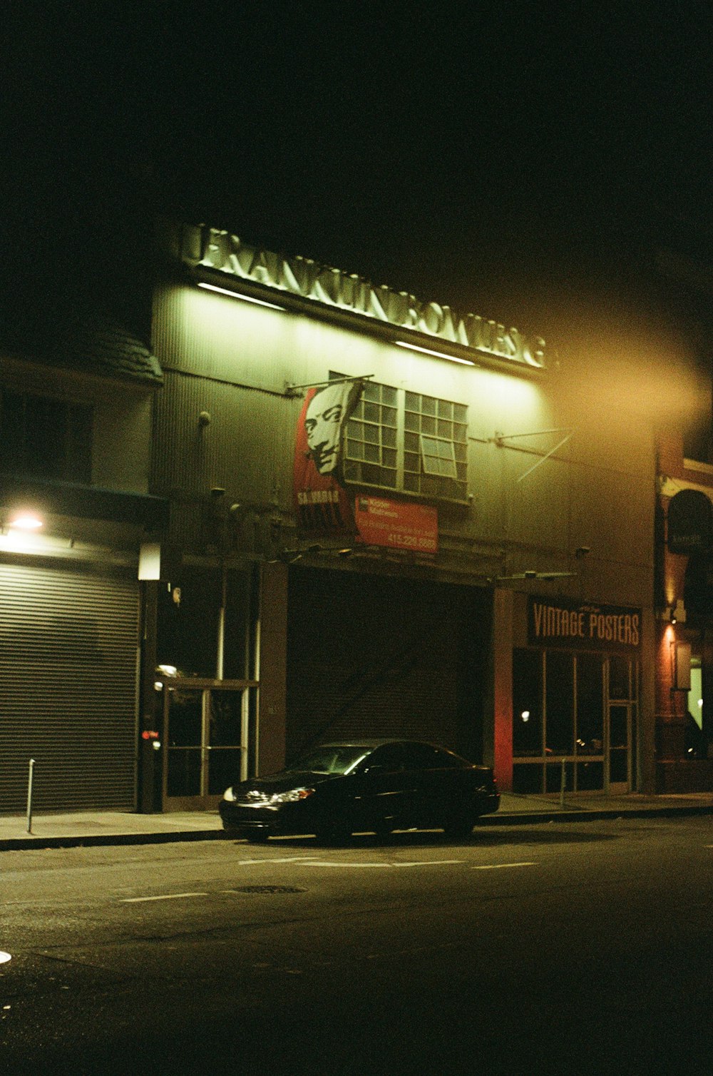 a car parked in front of a building at night