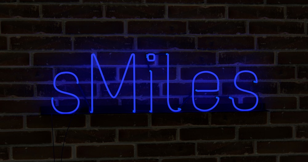 Eine blaue Leuchtreklame, auf der ein Lächeln auf einer Ziegelmauer steht