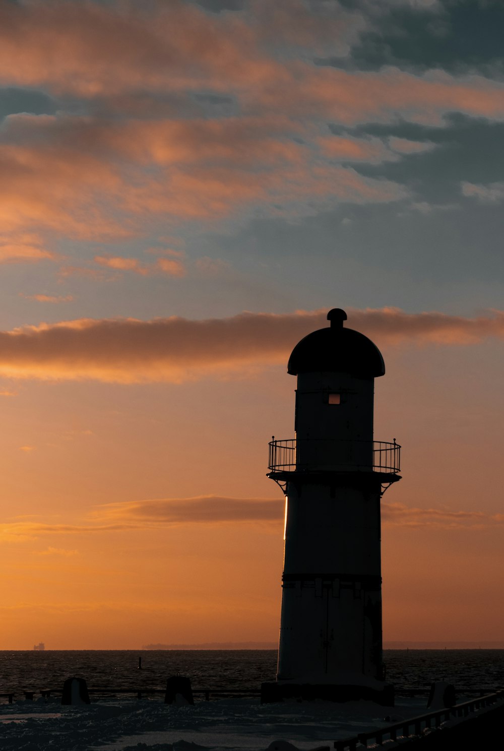 a light house sitting on top of a beach next to the ocean