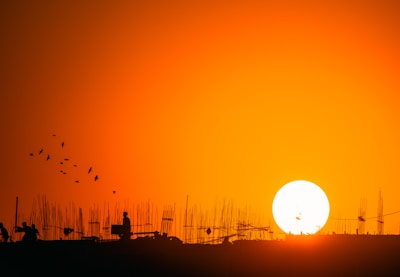 A vibrant sunset over a film set with crew members working.
