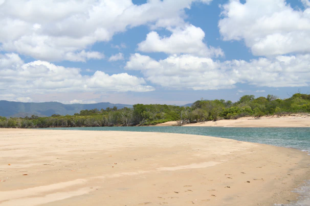 A serene beach with golden sand and turquoise water during sunset on a remote island.