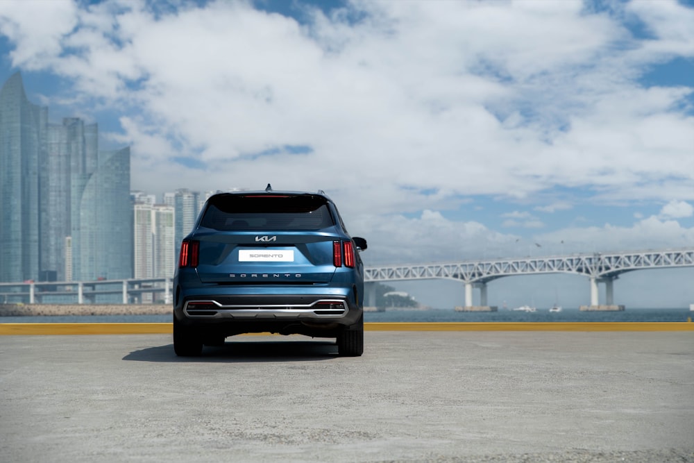 Un'auto blu parcheggiata davanti a un ponte