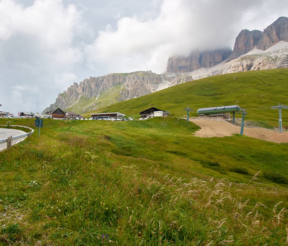ein grasbewachsenes Feld mit einer Straße und einem Berg im Hintergrund
