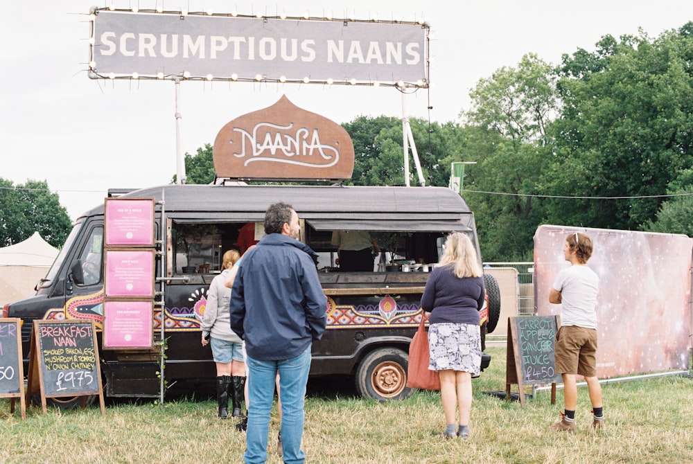 a group of people standing in front of a food truck