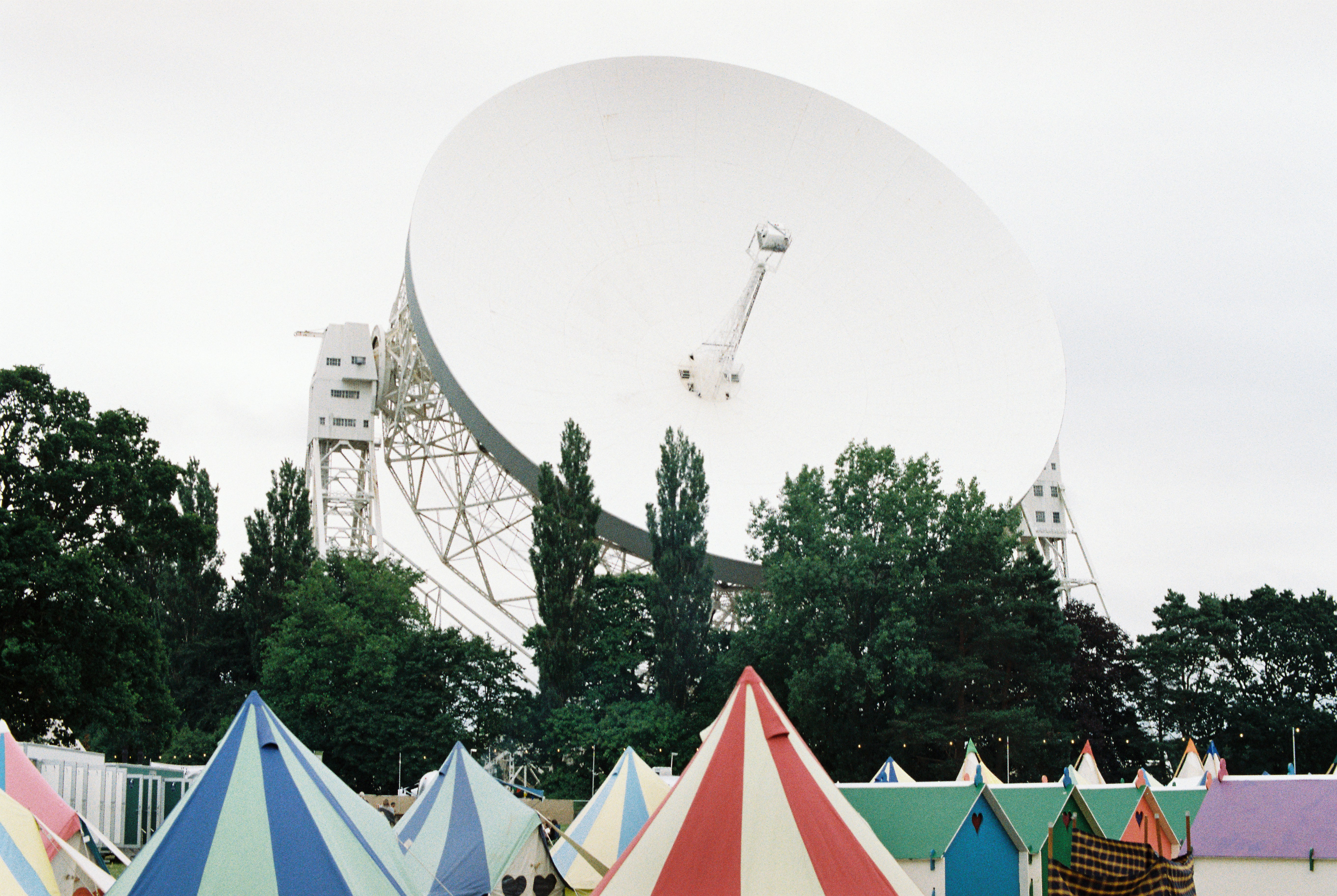 a group of tents with a satellite dish in the background