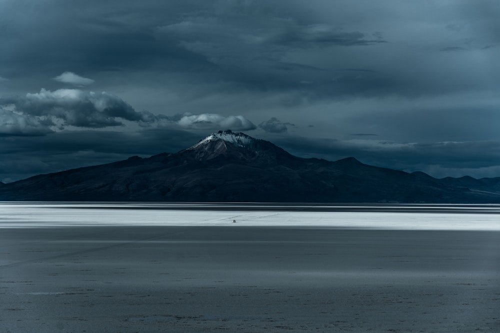 a large body of water with a mountain in the background