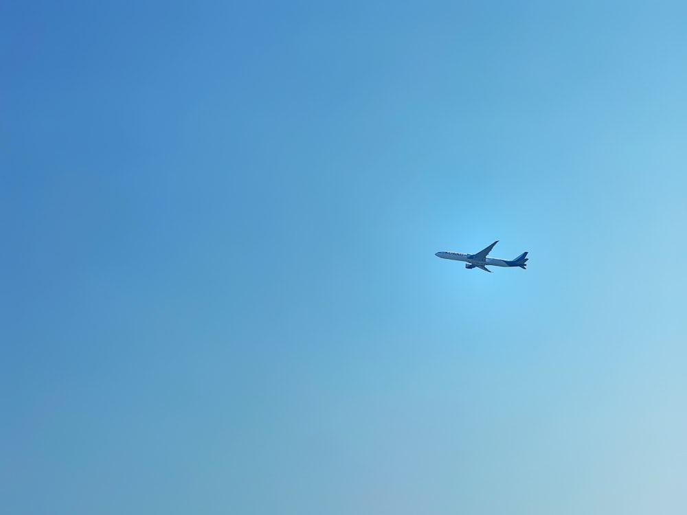 an airplane is flying in the blue sky