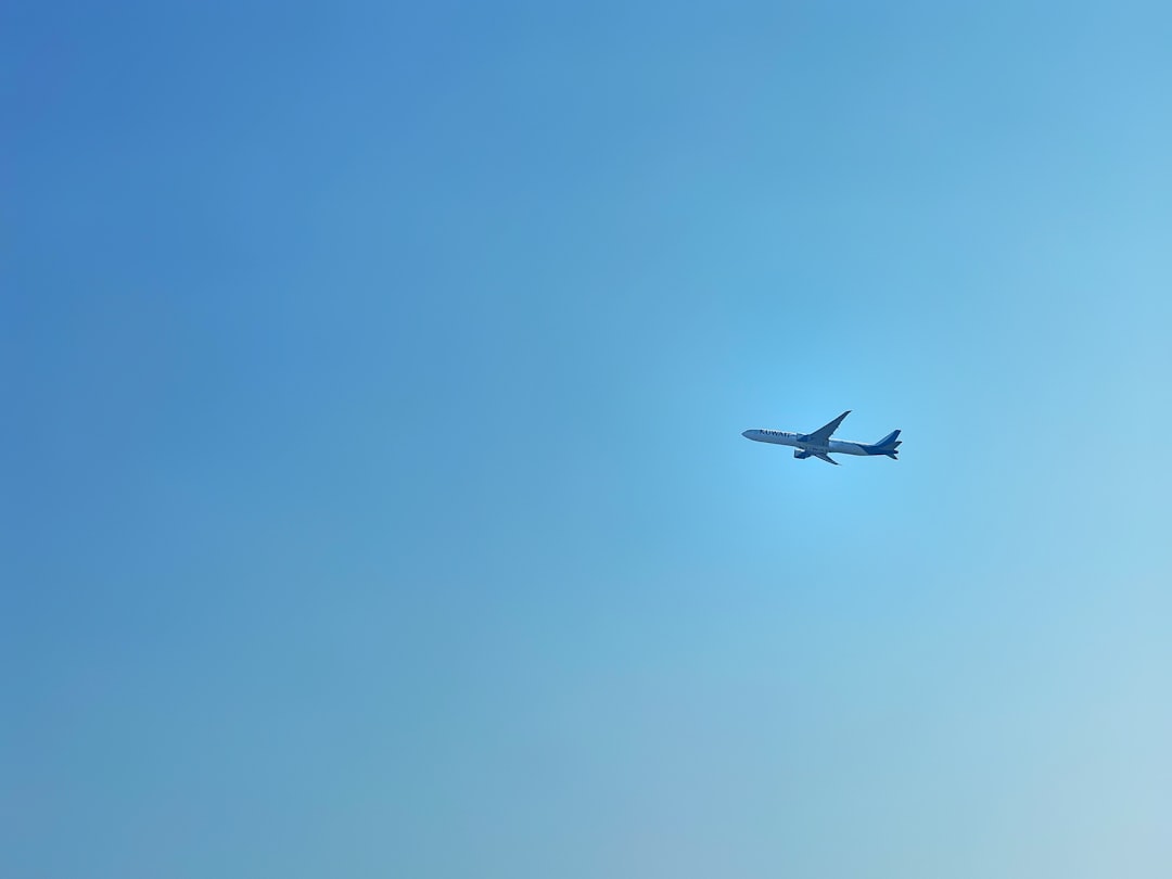 an airplane is flying in the blue sky, Kuwait airways airplane