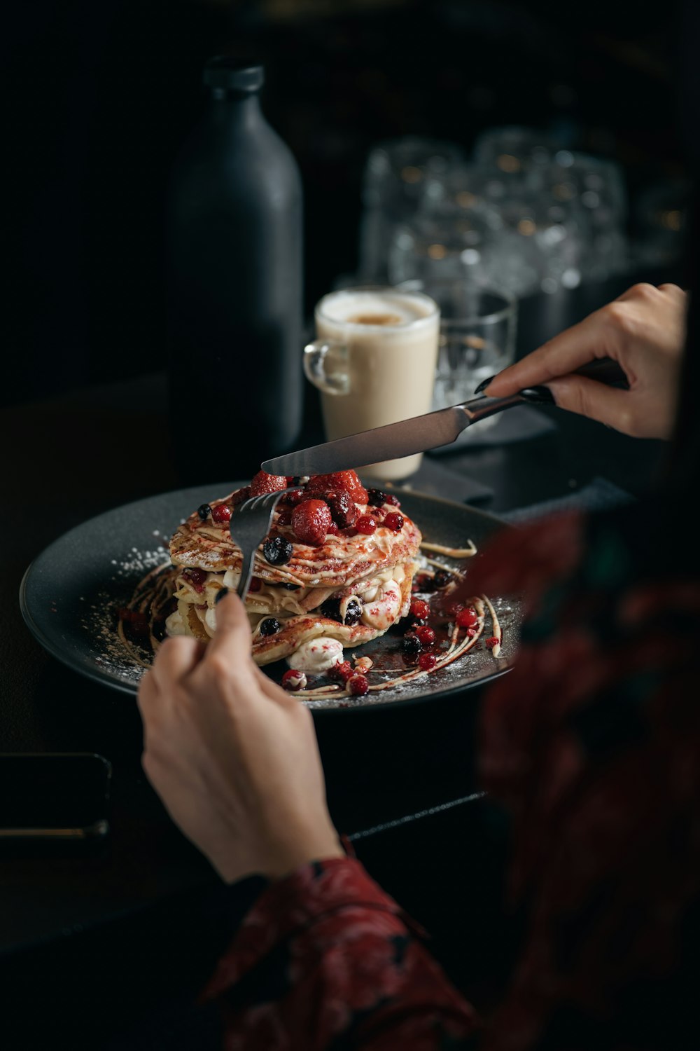 a person cutting a plate of food with a knife