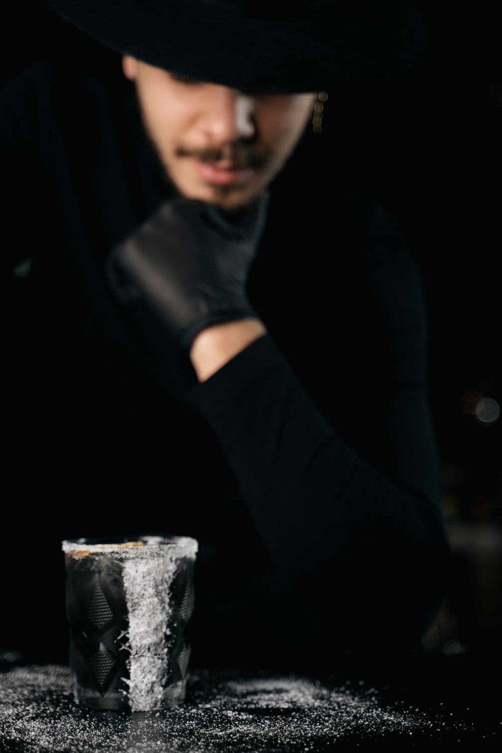 a man in a black hat is making a drink