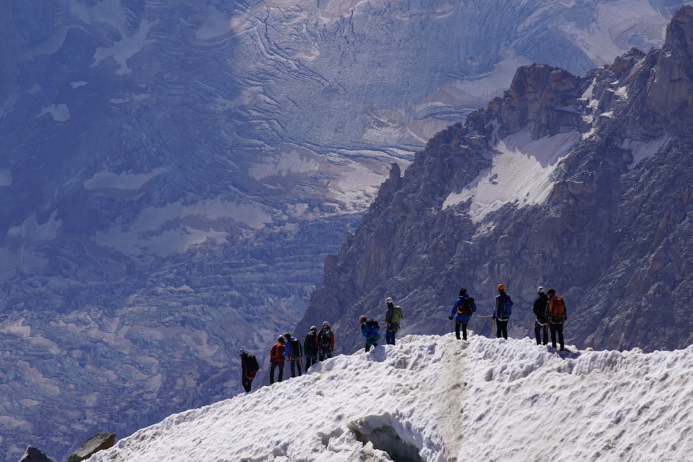 Un grupo de personas de pie en la cima de una montaña cubierta de nieve